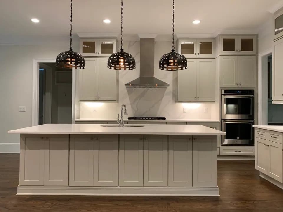 Greige shaker cabinets, marble slab backsplash and woven dome pendants