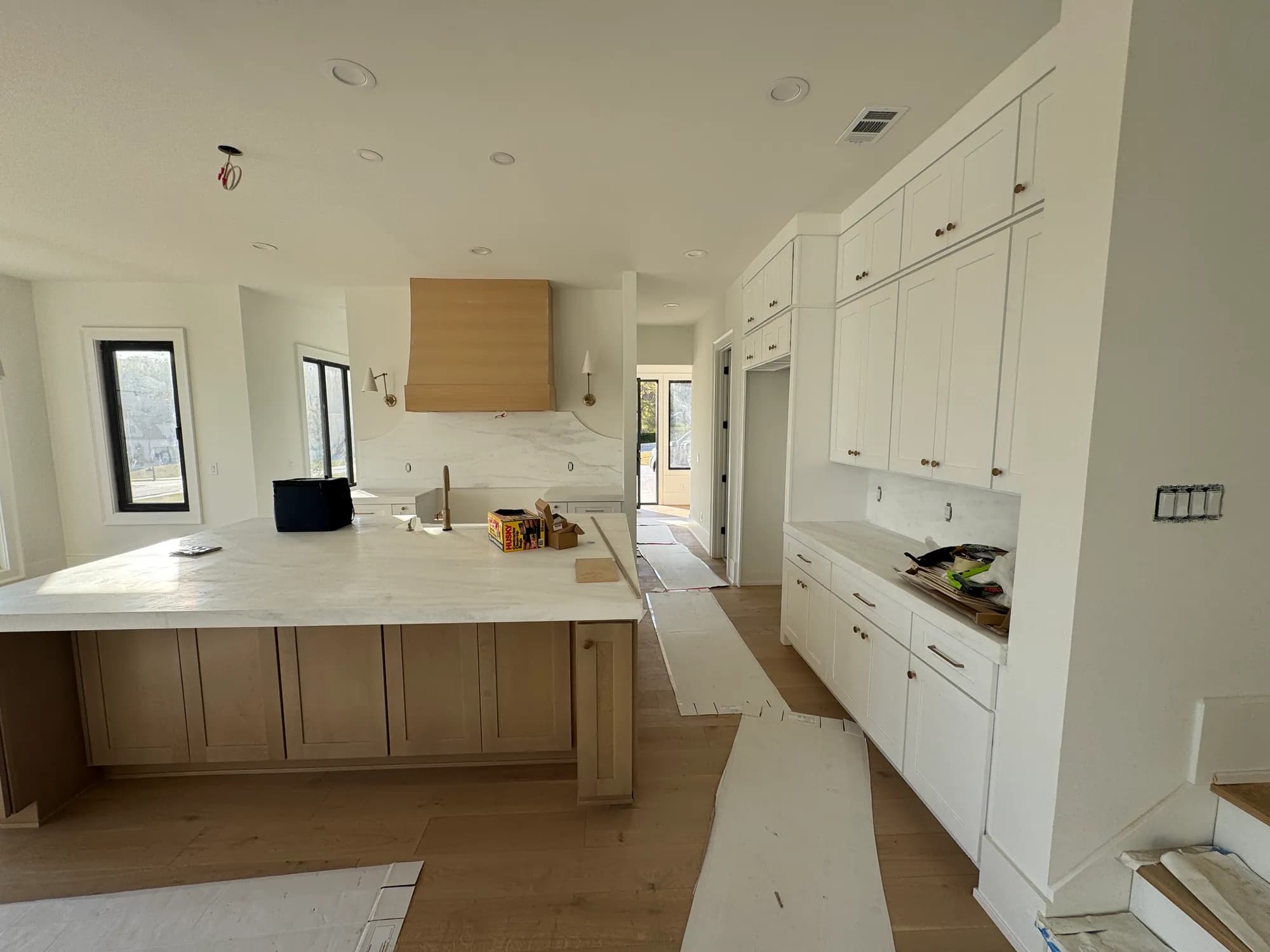 White oak island and wood range hood installed, countertops next